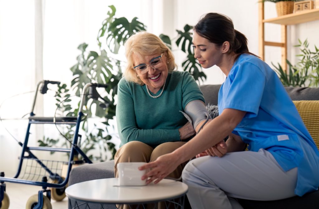 A nurse helps check a senior’s blood pressure in assisted living, as part of the medical care services offered